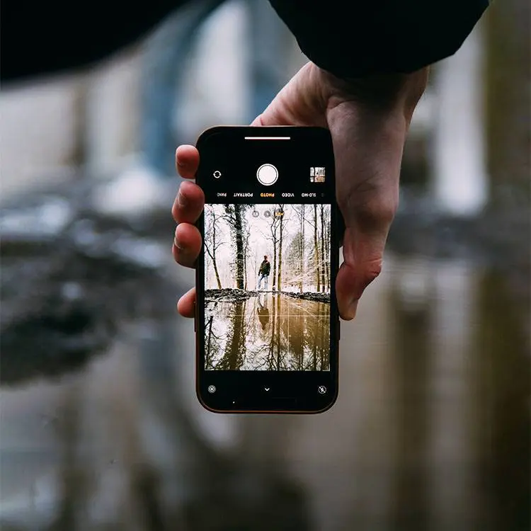 brecht-denil-wBH6wSm5KtU-unsplash a hand holding a cell phone